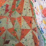 a man climbing on a climbing wall in a gym