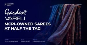 Garden Vareli brand audit by FashionAudit: Garden Vareli logo and the headline “MCPI-Owned Sarees at Half the Tag” over flowing printed georgette sarees draped over a wooden stand