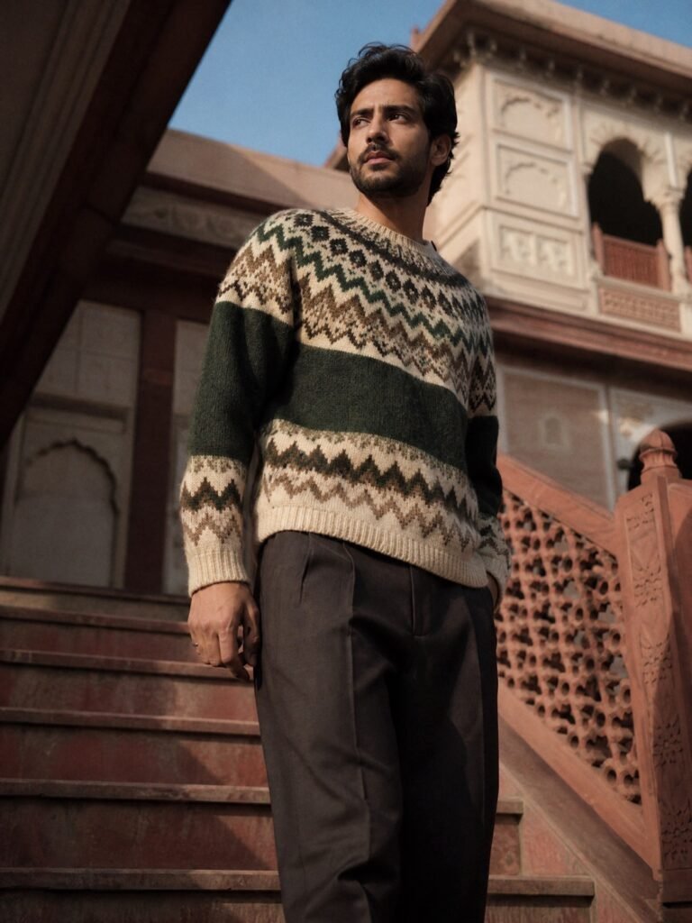 A man in a fuzzy Fair Isle sweater in cream, brown and forest green with tailored trousers